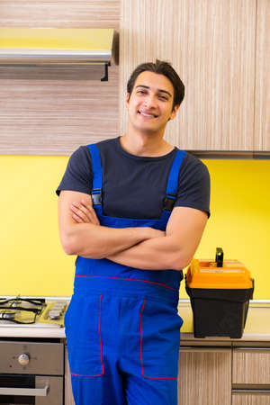 Young service contractor assembling kitchen furnitureの写真素材
