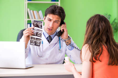 Pregnant woman visiting male gynecologyst at the clinicの写真素材