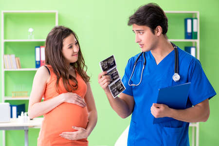 Pregnant woman visiting male gynecologyst at the clinicの写真素材