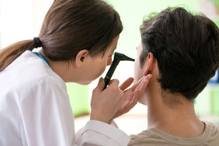 Female doctor checking patients ear during medical examination