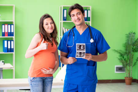 Pregnant woman visiting male gynecologyst at the clinicの写真素材
