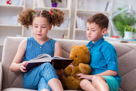 Two kids reading books at home