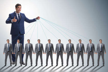 Boss employee manipulating his staff in business conceptの写真素材