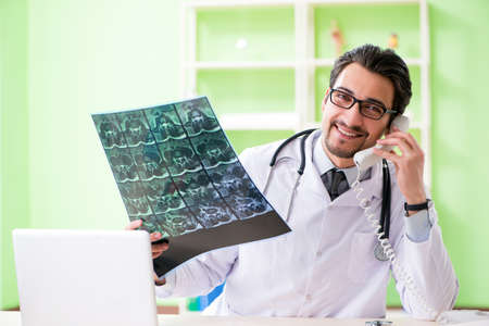 Doctor radiologist looking at x-ray scan in hospitalの写真素材