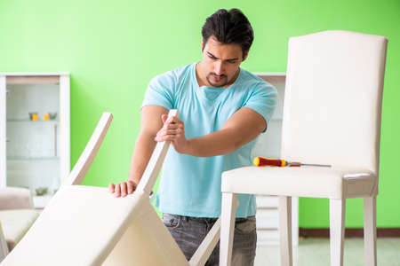 Man repairing furniture at homeの写真素材