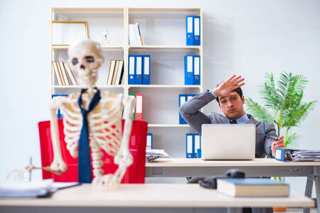 Businessman working with skeleton in office