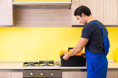 Young service contractor assembling kitchen furnitureの写真素材