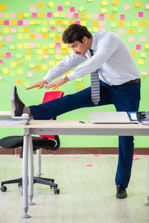 Man in the office with many conflicting priorities doing exercisの写真素材