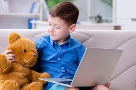Little boy surfing internet on laptop