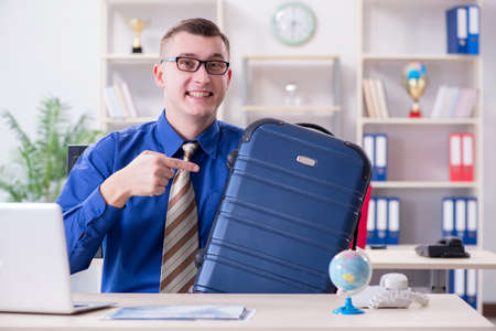 Young employee preparing for vacation tripの写真素材