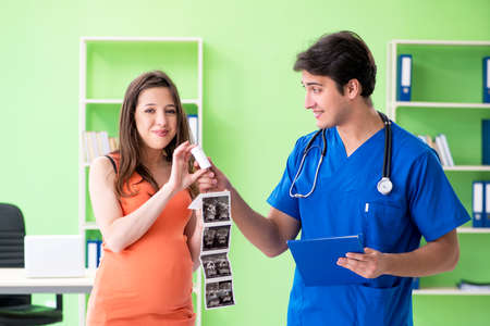 Pregnant woman visiting male gynecologyst at the clinicの写真素材