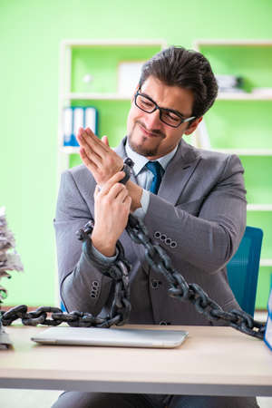 Employee chained to his desk due to workloadの写真素材