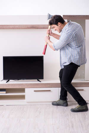 Man trying to fix broken tvの写真素材