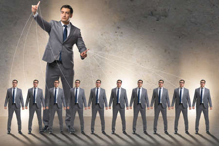 Boss employee manipulating his staff in business conceptの写真素材