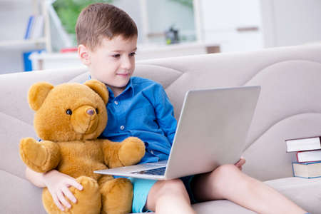 Little boy surfing internet on laptop