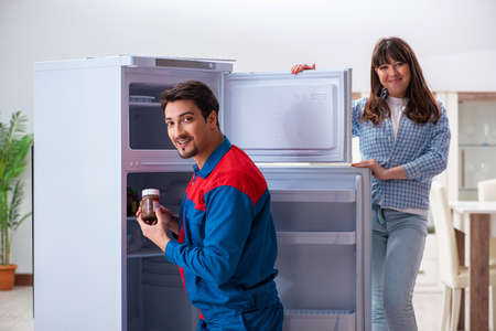 Man repairing fridge with customerの写真素材