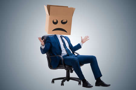 Businessman with box and unhappy faceの写真素材