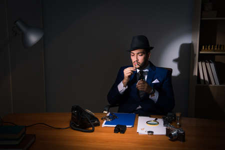 Detective sitting in dark room in vintage concept