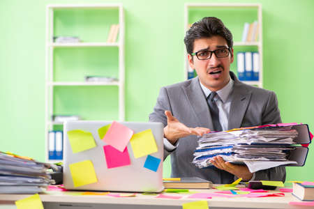 Businessman unhappy with many conflicting priorities sitting inの写真素材