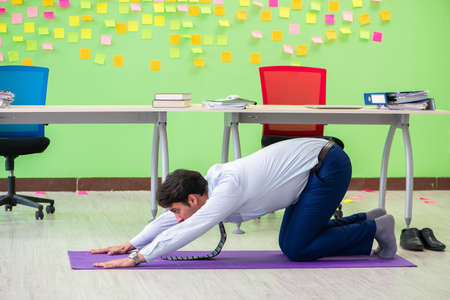 Man in the office with many conflicting priorities doing exercisの写真素材