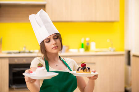 Young cook cooking cakes in the kitchenの写真素材