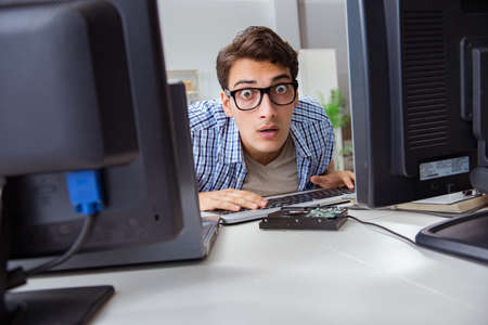 Young trader monitoring markets on screensの写真素材