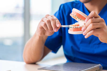 Man dentist working on new teeth implant