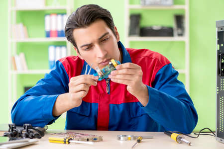 Computer engineer repairing broken desktopの写真素材