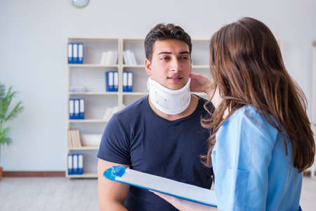 Man with neck injury visiting doctor for check-upの写真素材