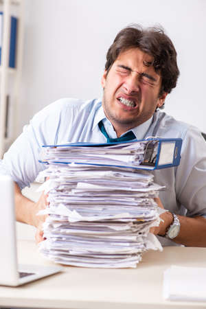 Overloaded busy employee with too much work and paperworkの写真素材