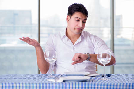 A handsome man alone in the restaurant on a dateの写真素材