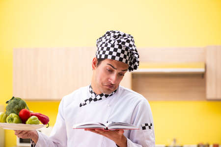 Young professional cook preparing salad at homeの写真素材
