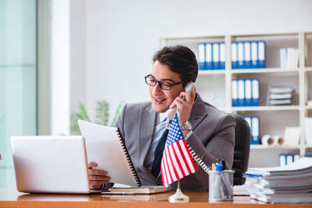 Businessman with American flag in officeの写真素材