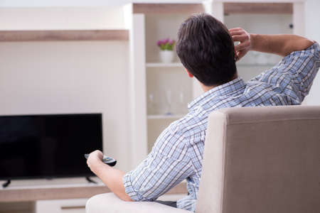 Young man watching tv at home