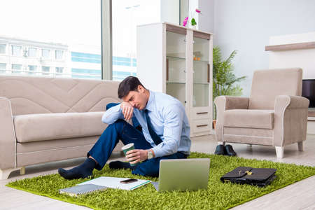 Businessman taking work home and working overtimeの写真素材