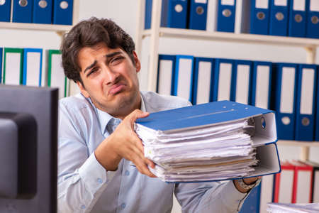 Overloaded busy employee with too much work and paperwork