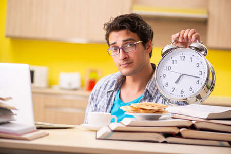 Student preparing for exam sitting at the kitchenの写真素材
