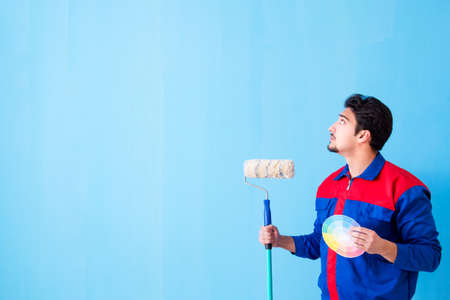Young man contractor choosing color from rainbow