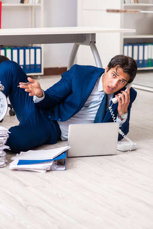 Tired exhausted businessman working overtime in officeの写真素材