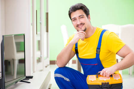 Male professional serviceman repairing tv at homeの写真素材