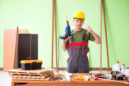 Young man carpenter working in workshop