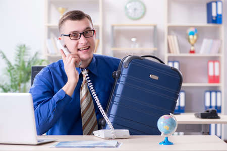 Young employee preparing for vacation tripの写真素材