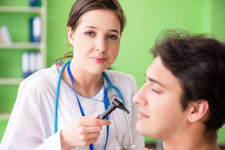 Female doctor checking patients ear during medical examinationの写真素材