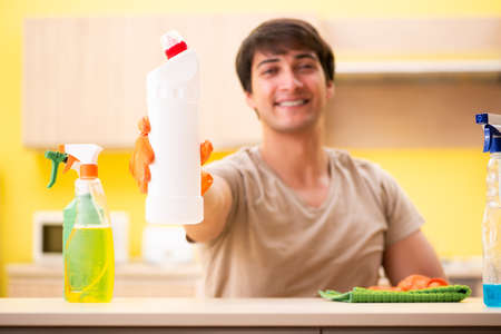 Single man cleaning kitchen at home