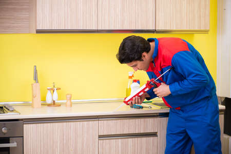 Repairman working in the kitchenの写真素材