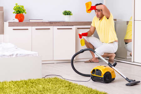 Young handsome man cleaning in the bedroomの写真素材