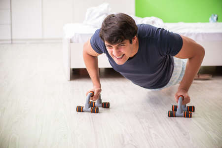 Young man in pajamas doing morning exercises