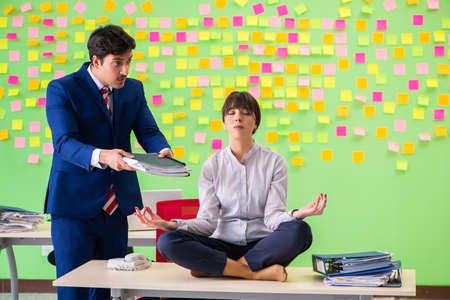 Man and woman in the office with many conflicting priorities.の写真素材