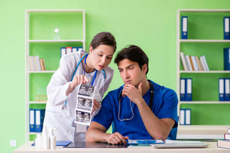 Woman and man gynecologists discussing medical case at the clini
