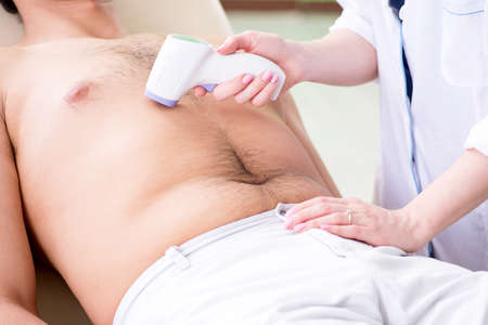 Young man visiting doctor for epilationの写真素材